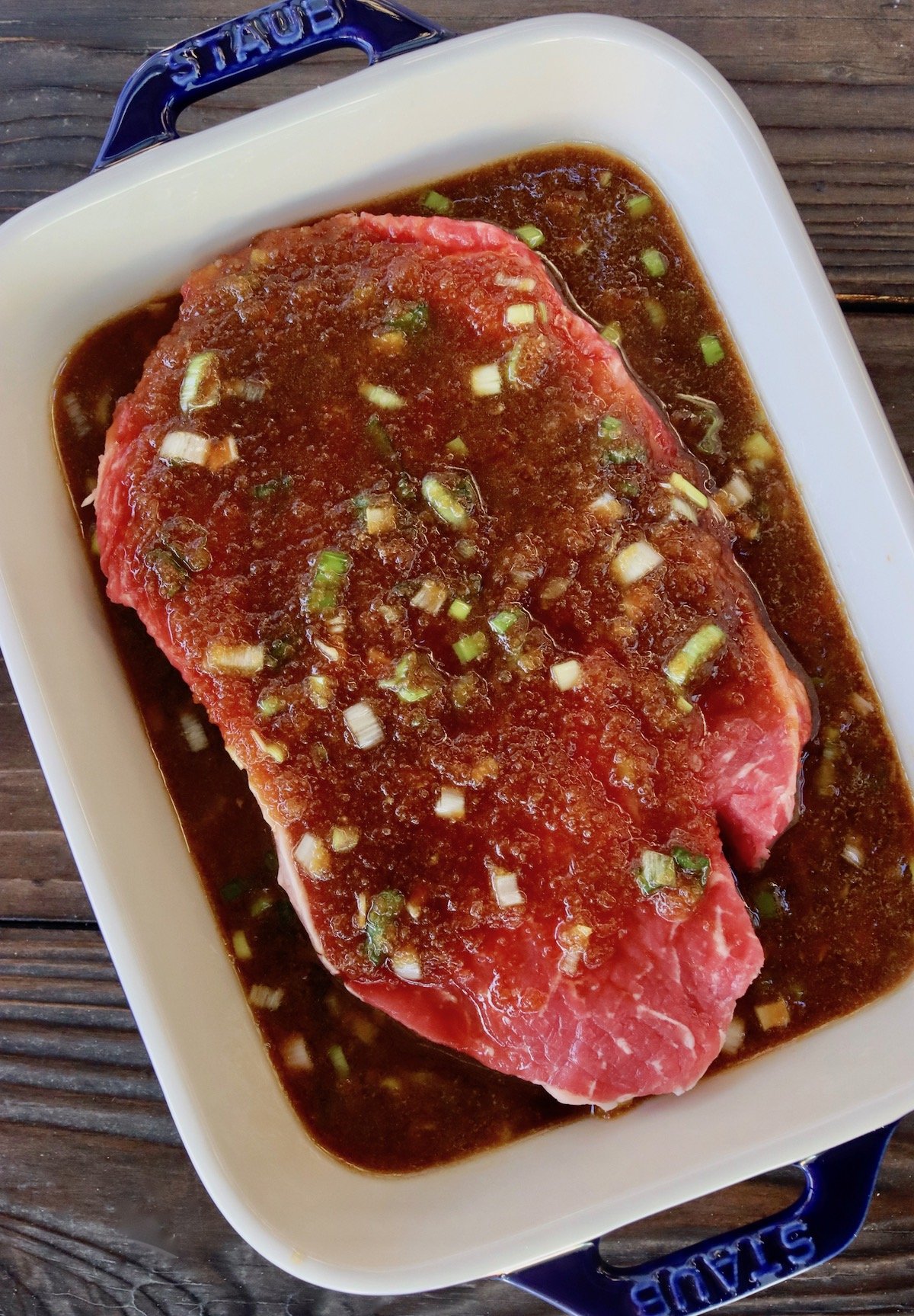 raw rib-eye steak in baking dish with asian pear marinade