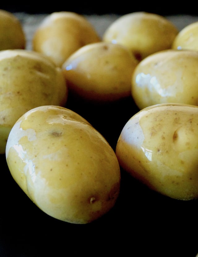 Sheet pan full with Baby Dutch Yellow Potatoes with olive oil.