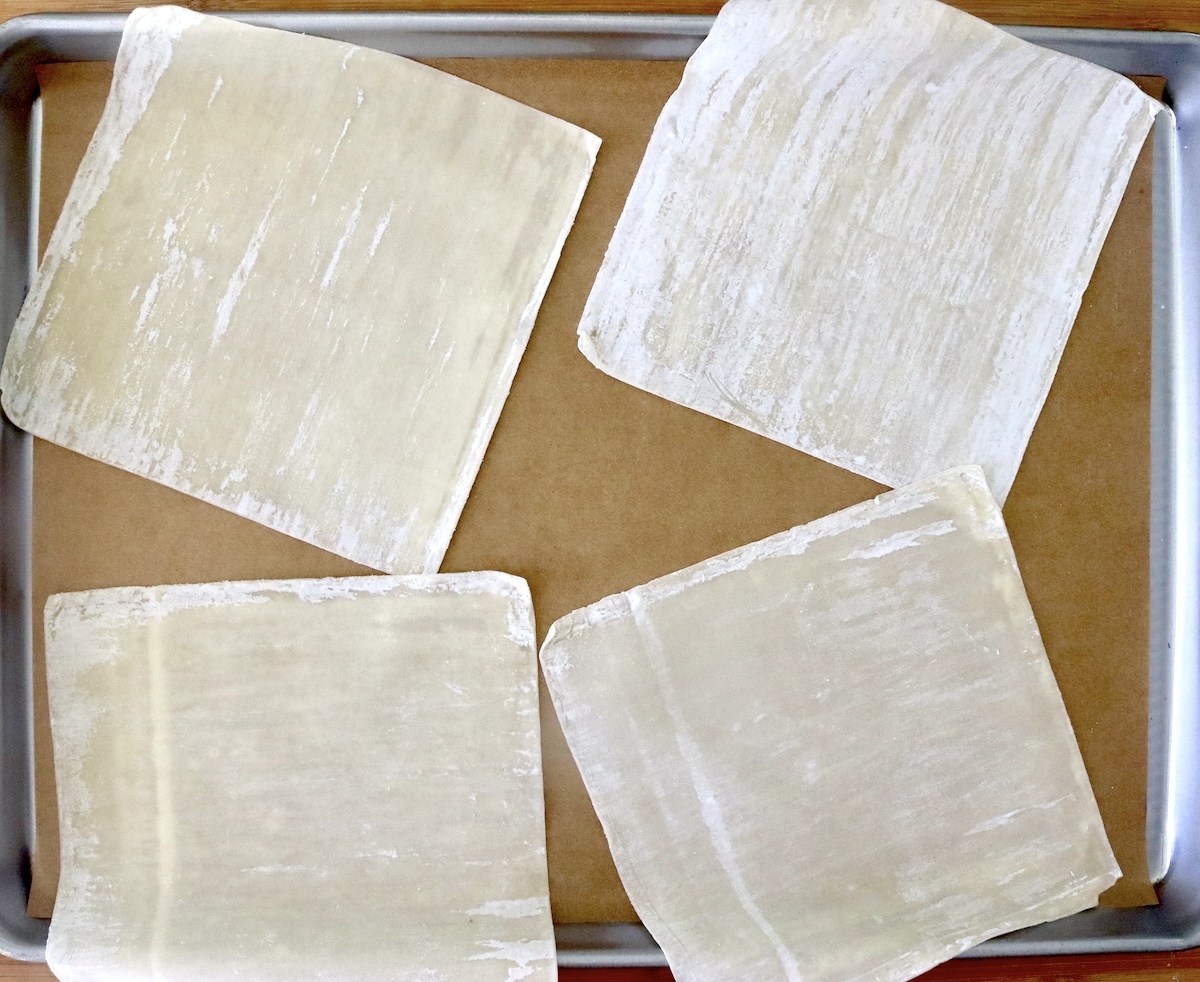 Baked-Asian-Pear-Recipe Four 6 x 6 wonton wrappers on a parchment-lined baking sheet.
