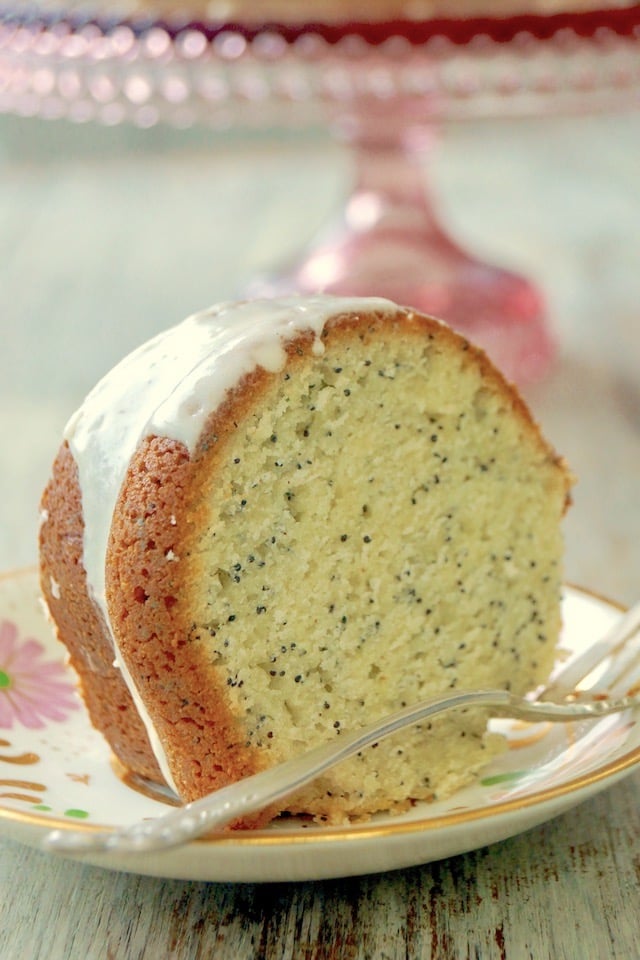 One slice of Eggnog Bundt Cake with Poppy Seeds on a pink floral plate.