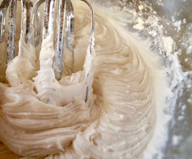 whipped buttercream in bowl with beaters