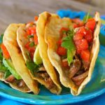 two pulled pork tacos on a turquoise plate