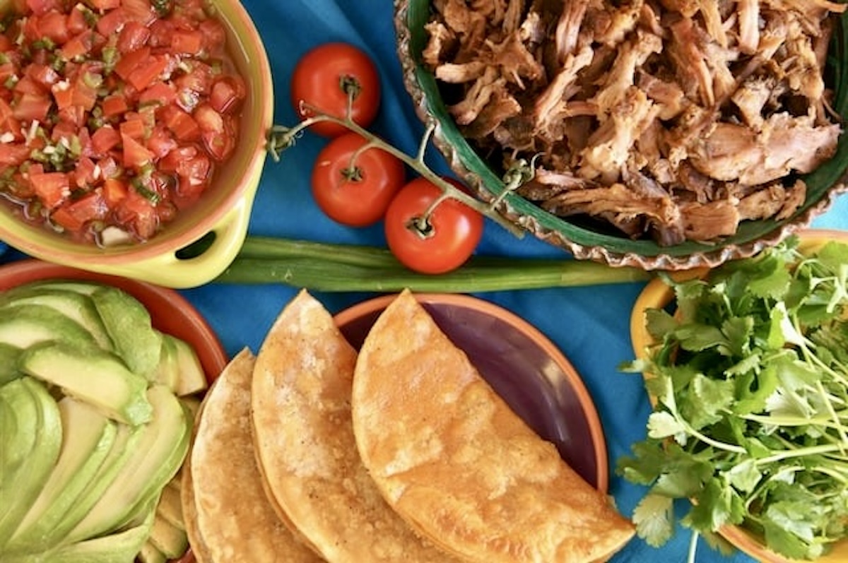 Pickled-Tomato-Pulled-Pork-Tacos Ingredients for Pulled Pork Pickled Tomato Tacos on a blue cloth.