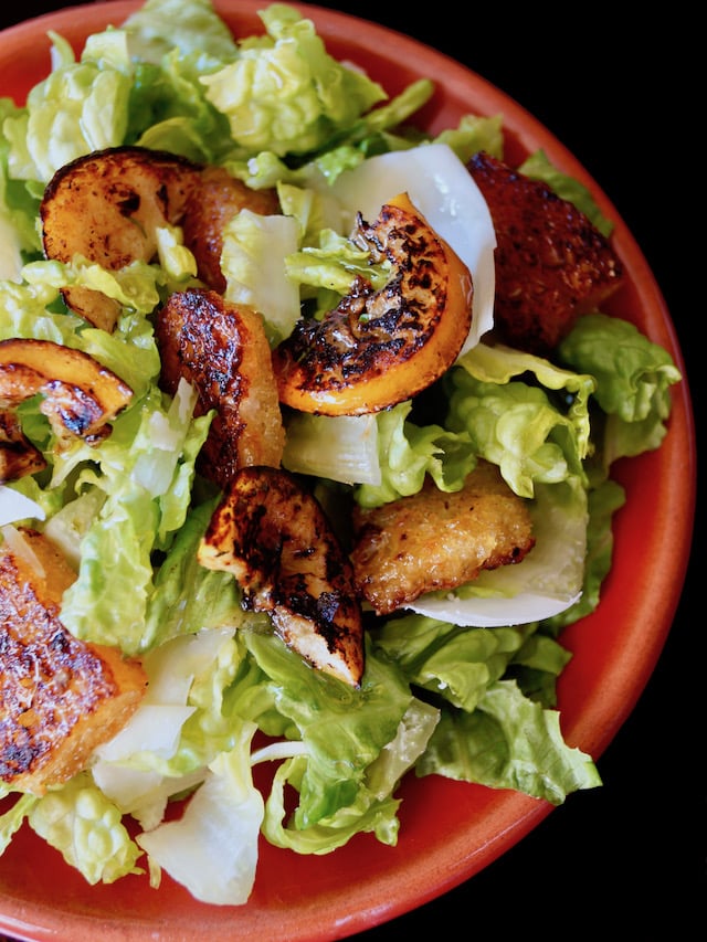 Close up of Fried Lemon Caesar Salad on a red plate