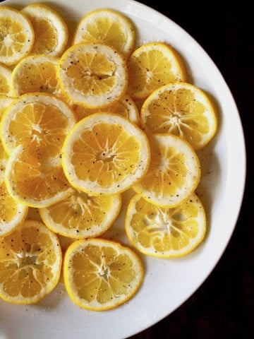 Large white plate full of lemon slices.