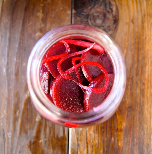 Top view of pickled Beets and onion in a jar on wood background.