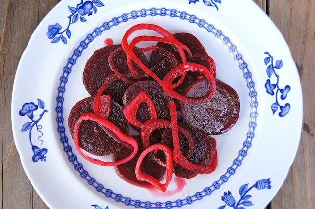 pickled beets and onions on a white and blue plate