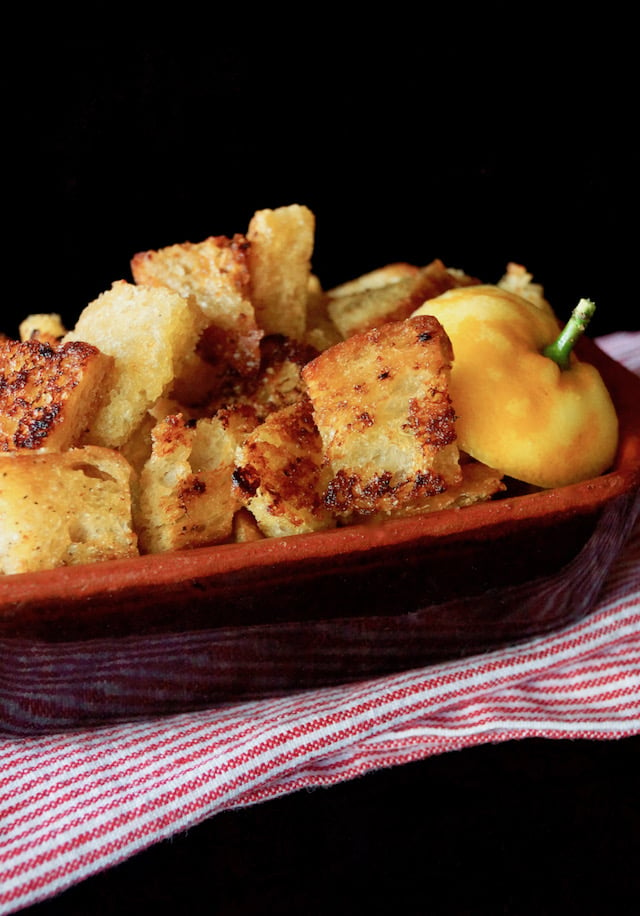 Lemon Garlic Roasted Croutons in a brown ceramic dish.