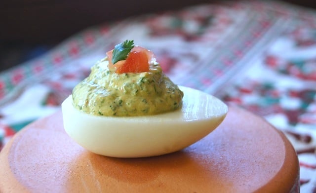 One Spicy Cilantro Deviled Egg on a teracotta plate.