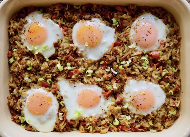 Bacon Hash Brown Casserole with six fried eggs on top