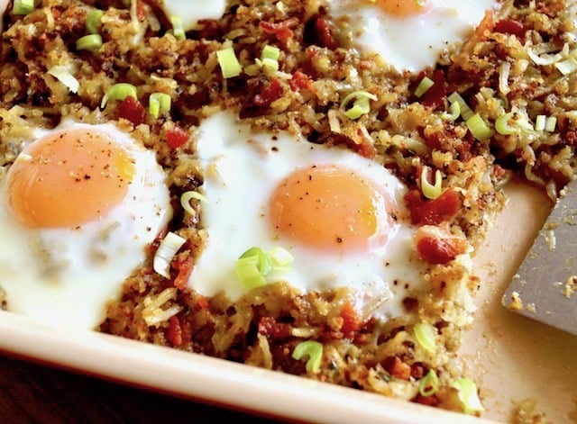 Bacon Hash Brown Casserole with fried eggs on top and slice removed