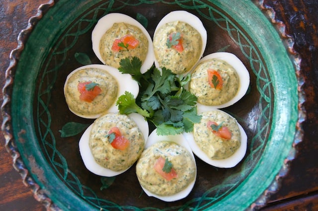 Spicy Cilantro Deviled Eggs with fresh cilantro in a green bowl