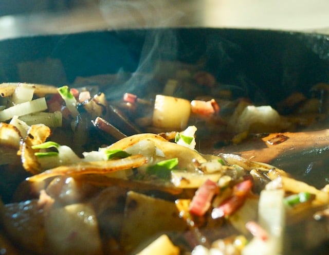 Cast iron skillet with chopped Swiss chard sauteeing.