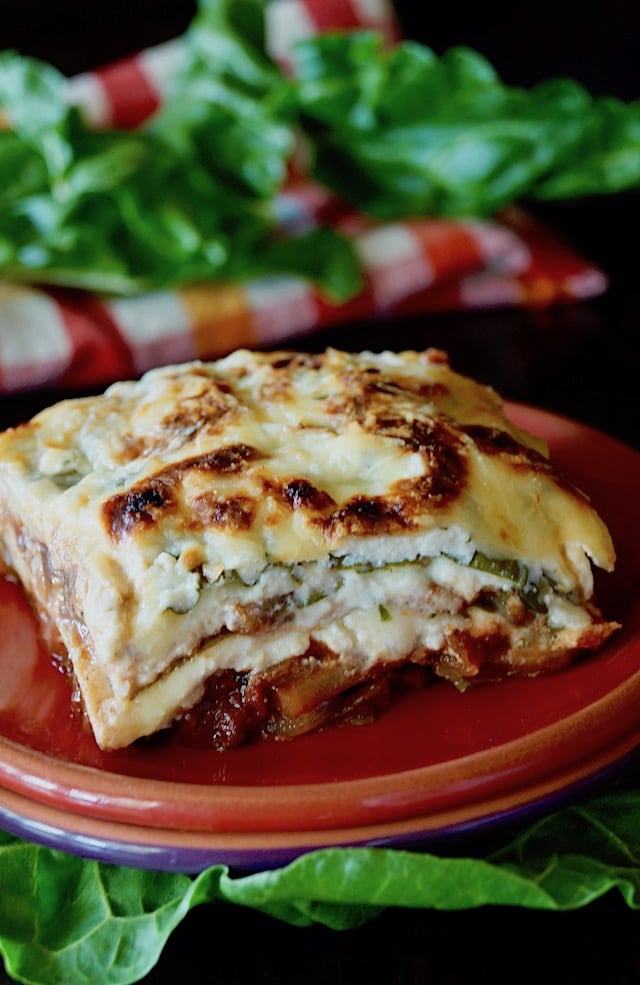 Slice of gluten-free, vegetarian Swiss Chard Lasagna on a red plate.