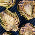Halved artichokes grilled on the grill.
