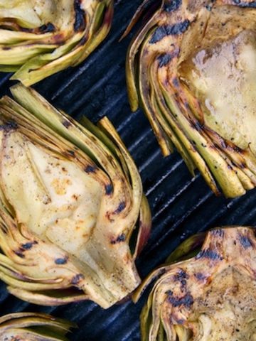 Halved artichokes grilled on the grill.