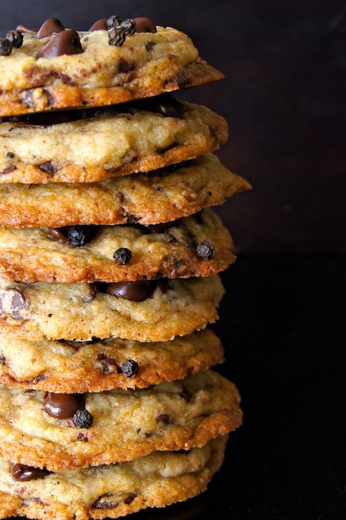 Tall stack of Kampot Black Pepper Chocolate Chip Cookies with black background.