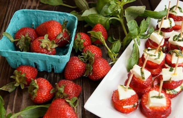 Strawbery Caprese with Lemon and Basil on a white plate.