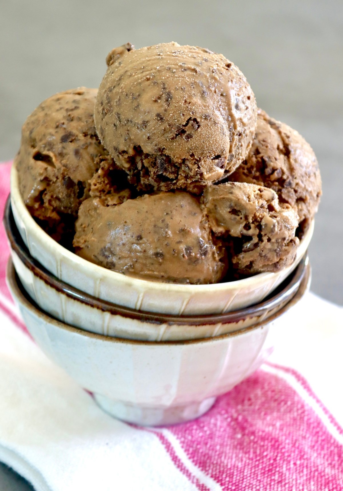 A few scoops of Espresso Gelato with Kahlua in a cream-colored bowl with two bowls below it.