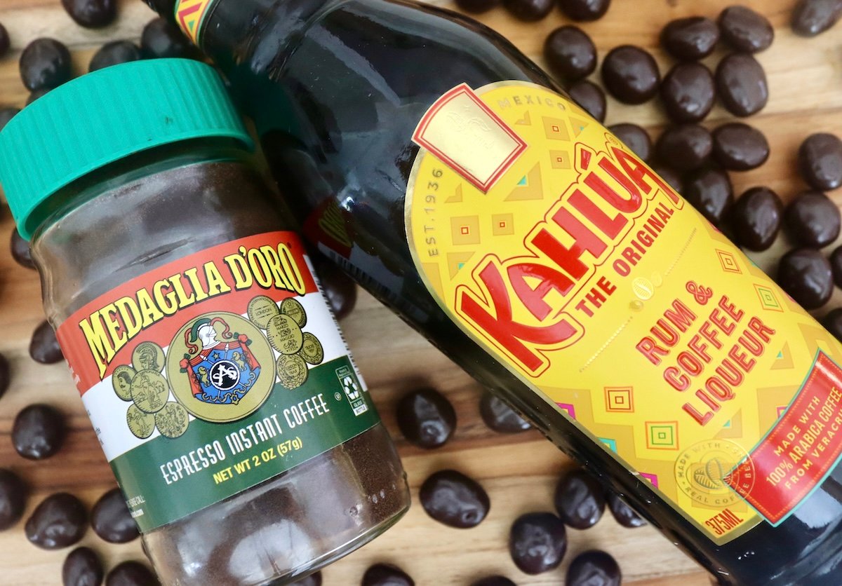 Bottle of Kahlua, and a jar of espresso powder surrounded by chocolate covered espresso beans.