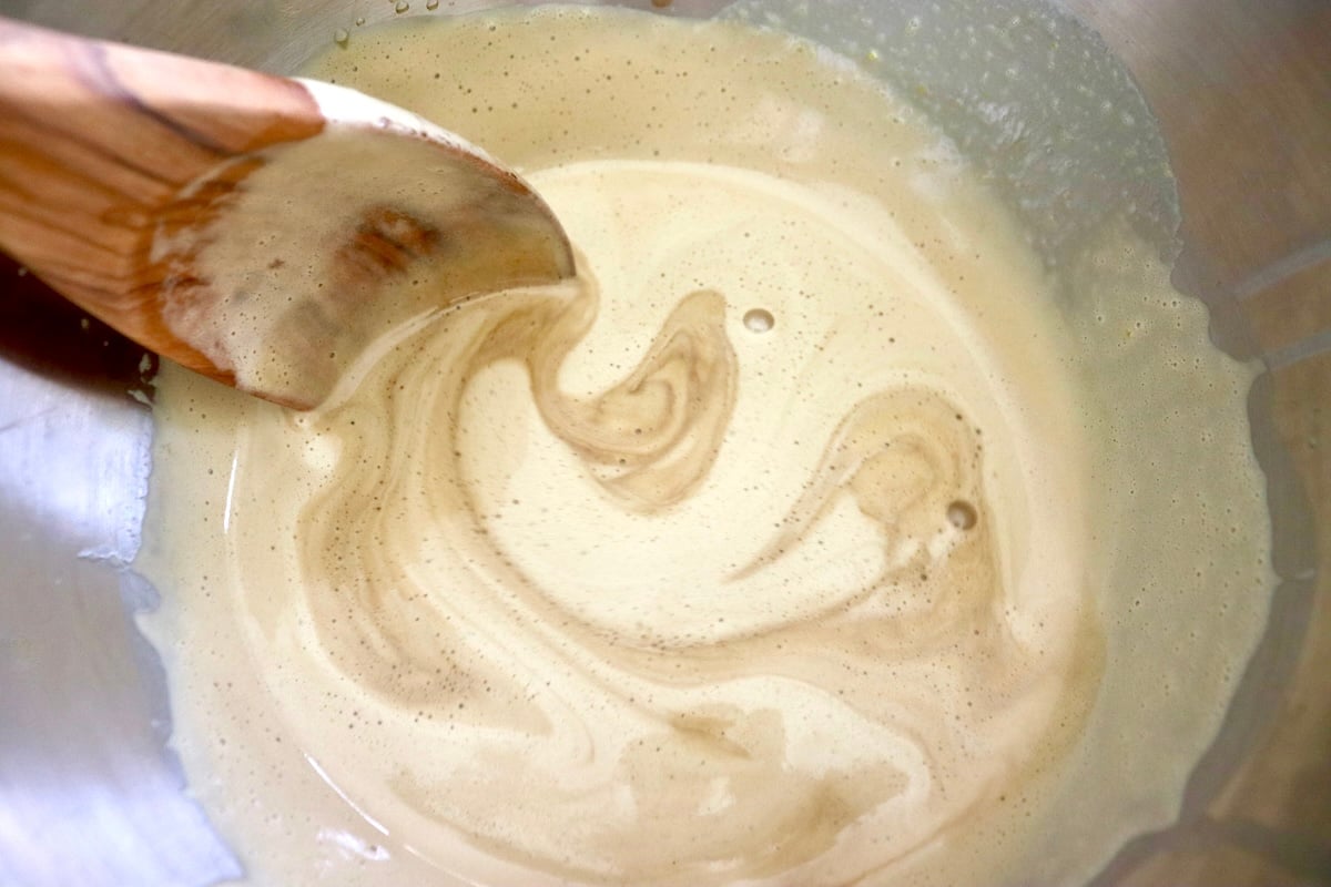 Swirled gleato base of egg mixture and espresso-milk mixture, with a wooden spoon.