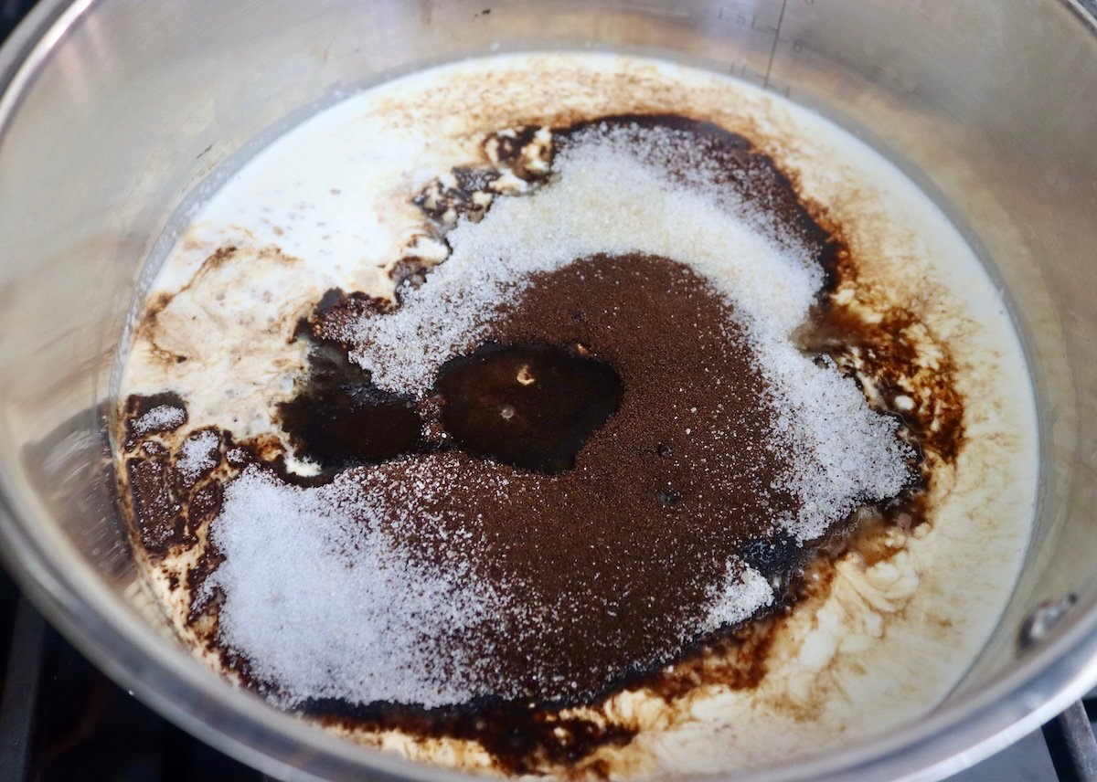 Pot with milk, espresso powder, sugar and vanilla.