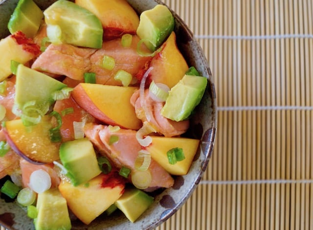 Sockeye Salmon Recipe with Peaches and Avocado in ceramic bowl on sushi mat