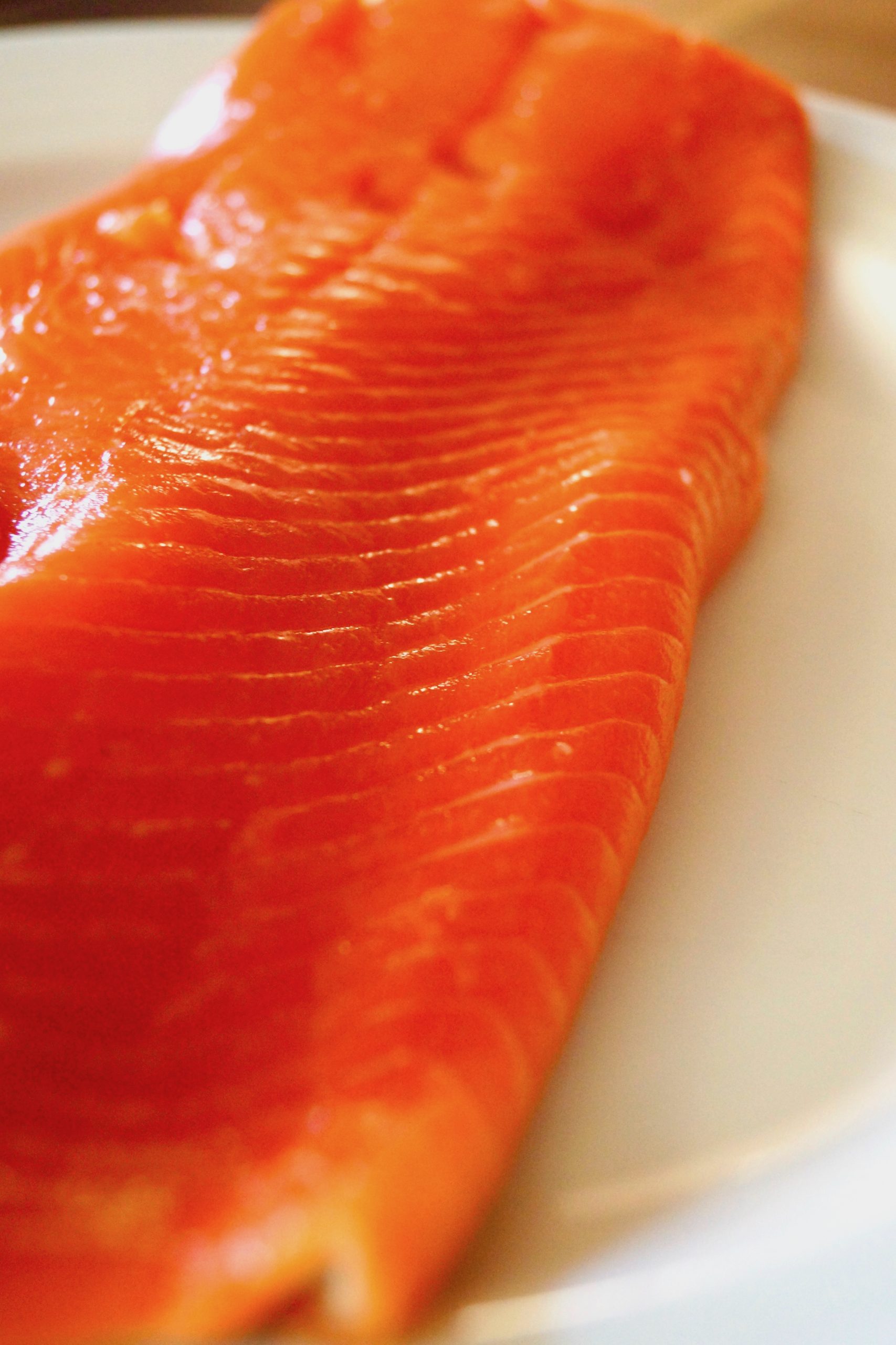 Large, raw sockeye salmon fillet on cutting board.