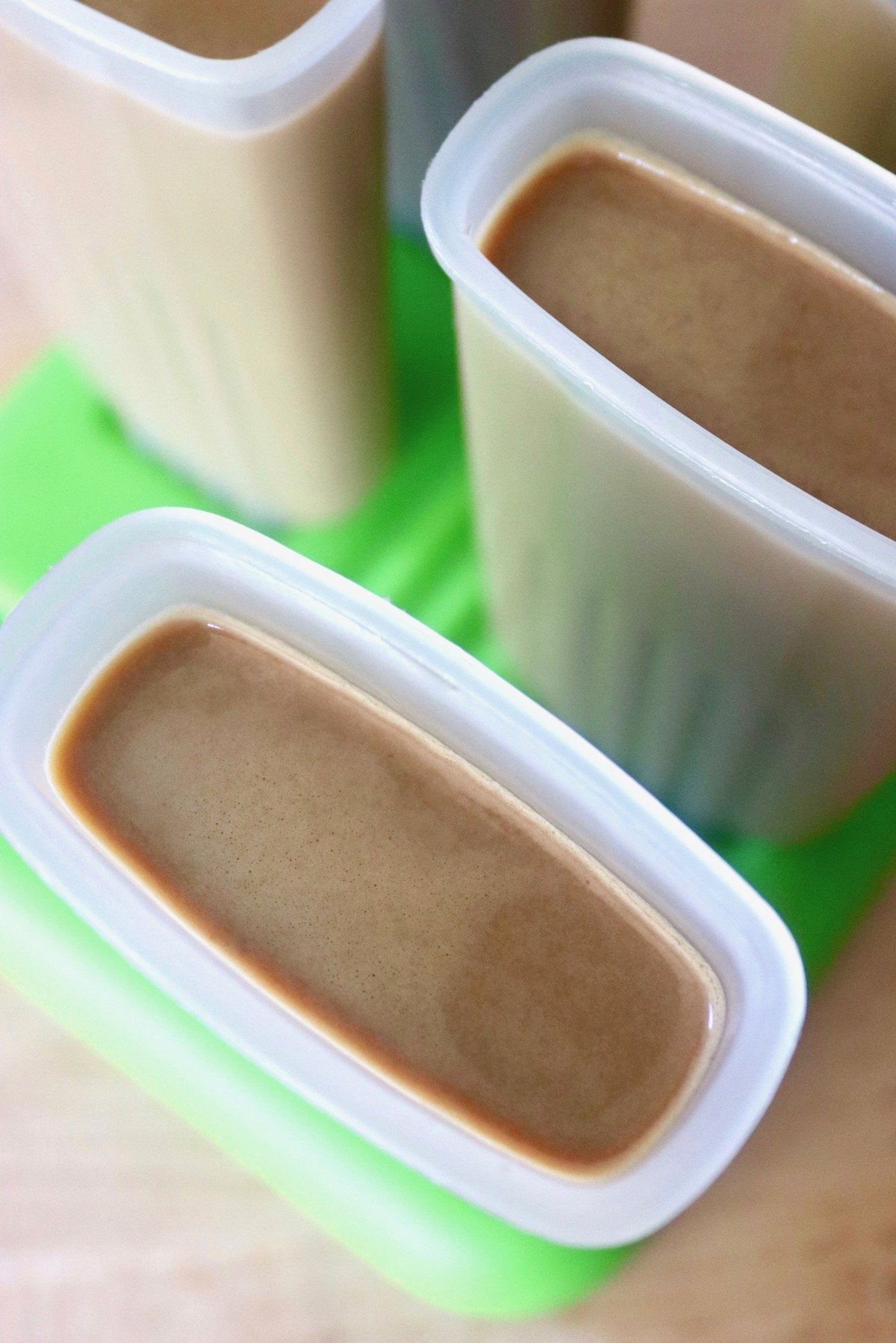 Popsicles molds fill with creamy coffee mixture.