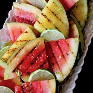 long white platter with red and yellow sliced, grilled watermelon