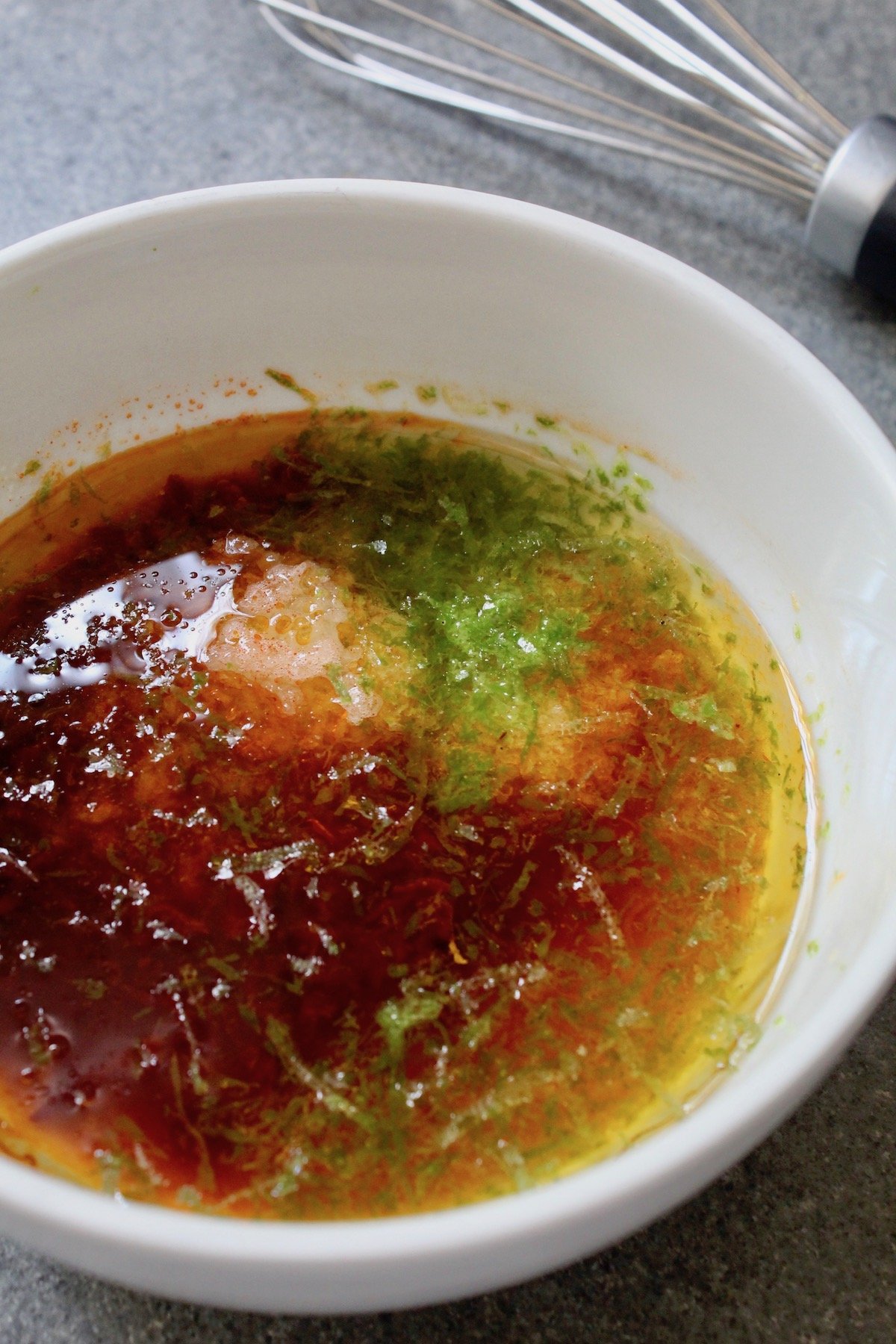marinade with lime zest, chipotles, oil and garlic, in white bowl