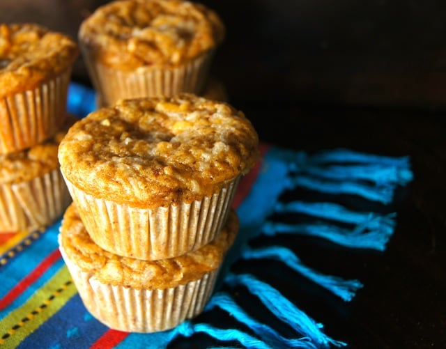 A few stacks of 2 Mesquite Chipotle Cheddar Cheese Muffins on colorful cloth.