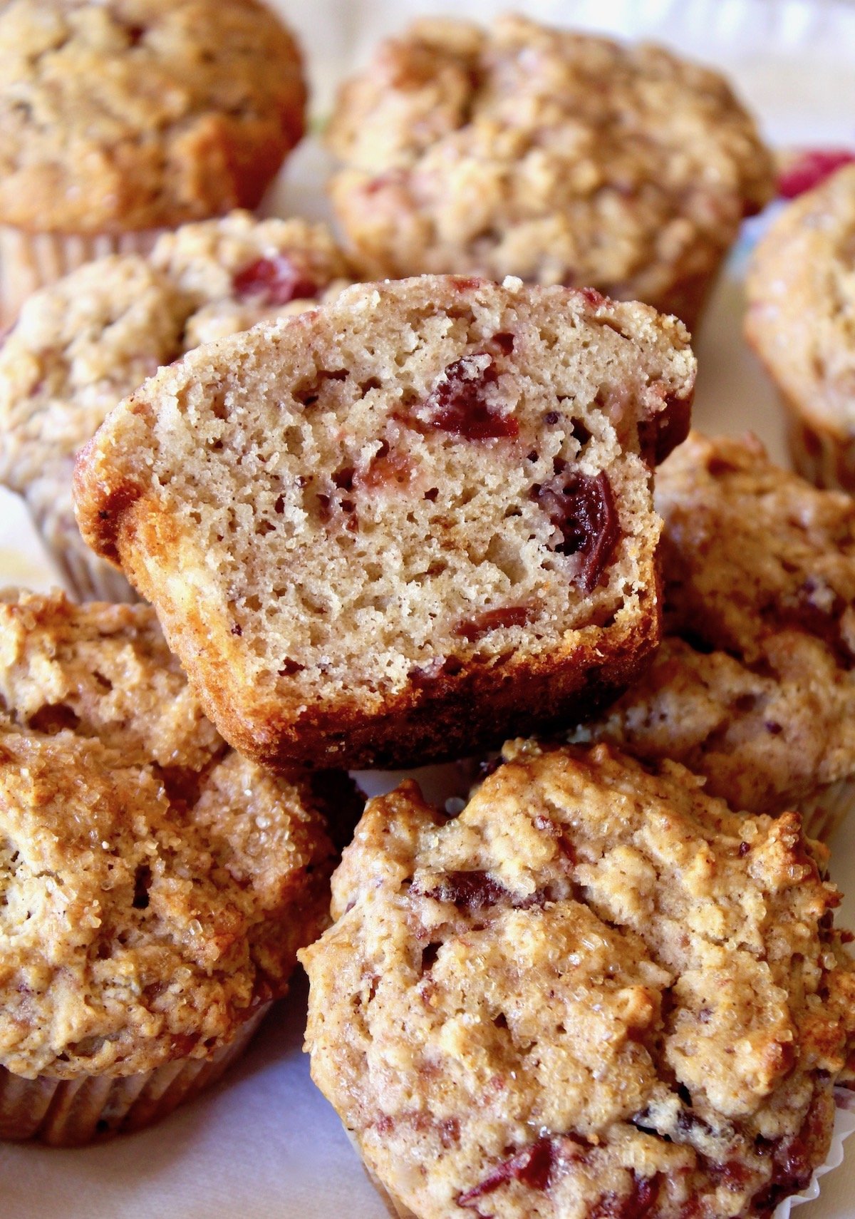 pile of Cranberry Sauce Muffins with one cut in half on top