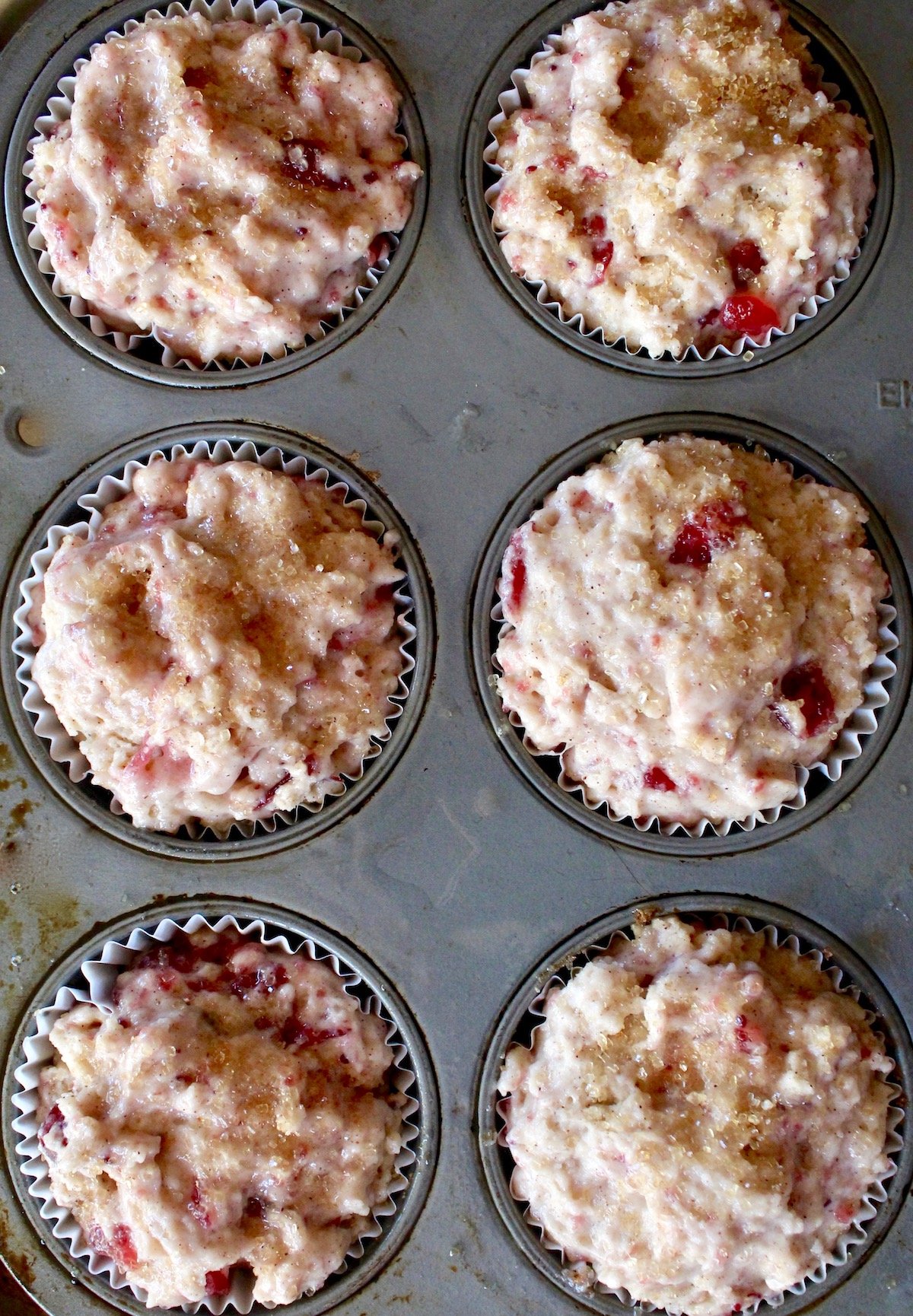 Muffin pan filled with cranberry muffin batter