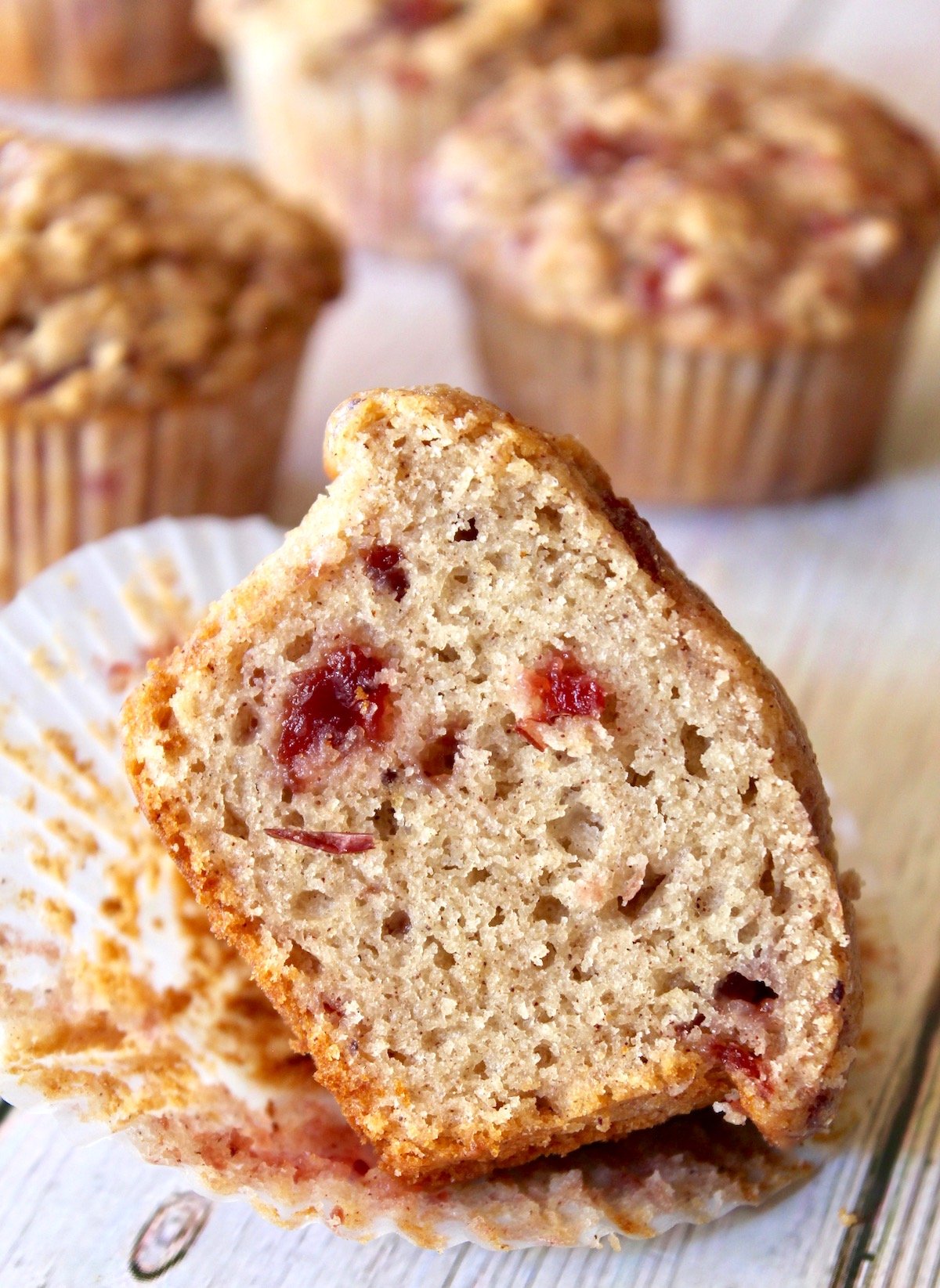 Half of a cranberry sauce muffin on paper muffin cup