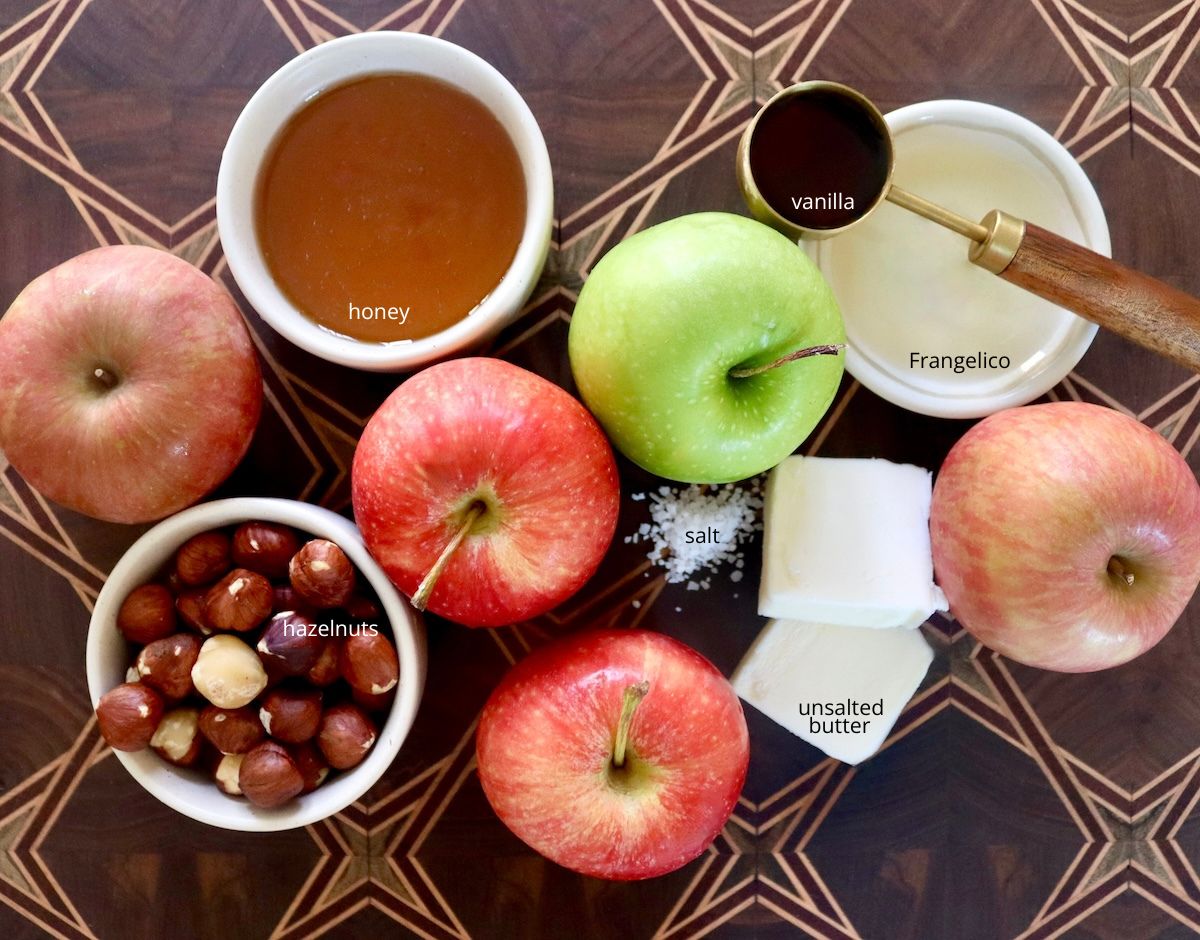 Ingredients for honey baked apples including honey, vanilla, apples, hazelnuts and frangelico.