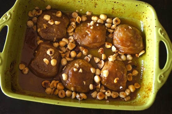 green baking dish with roasted apples and hazelnuts