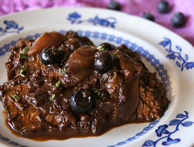 Blueberry Balsamic Braised Brisket on a white and blue plate