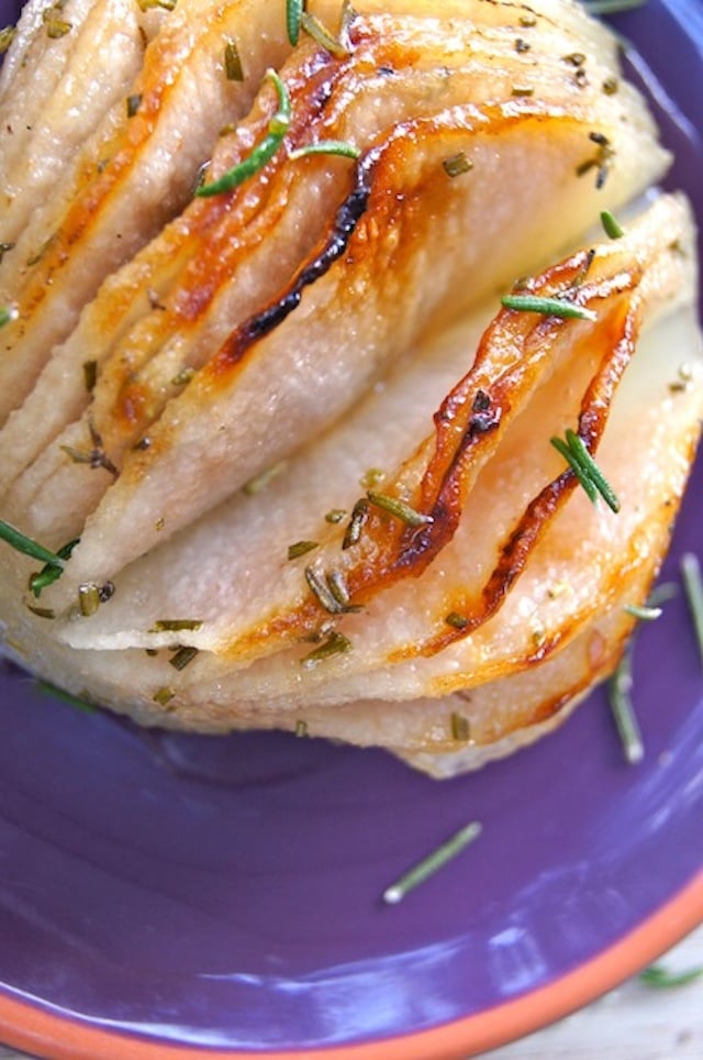 close up of a Rosemary Roasted hasselback Korean Pear with fresh rosemary leaves