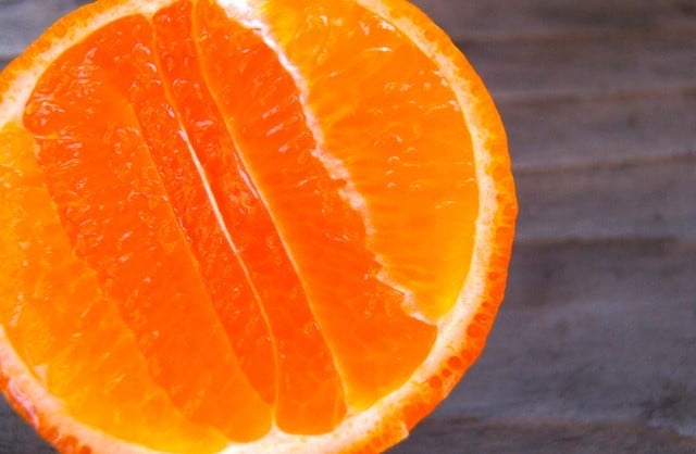 Half of a tangerine on wood surface