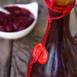 Creamy Cranberry Balsamic Dressing in a tall bottle with a red string.