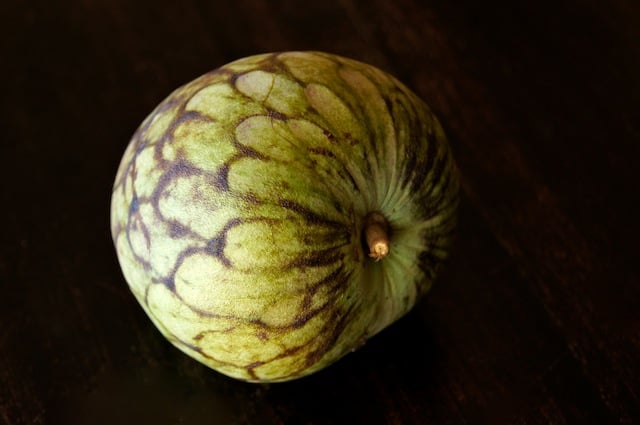 one cherimoya on black background