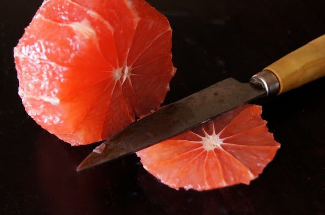 peeled citrus being cut into slices