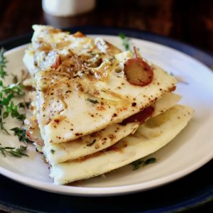 Stack of three slices of egg white potato frittata on white plate.