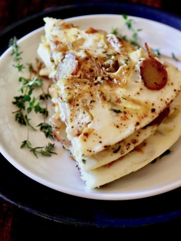 Stack of three slices of egg white potato frittata on white plate.