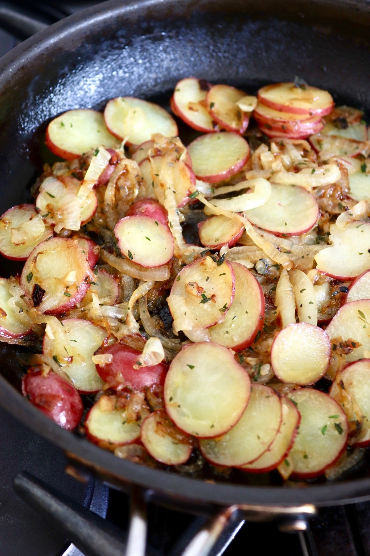 sliced potatoes and caramelized onon in saute pan