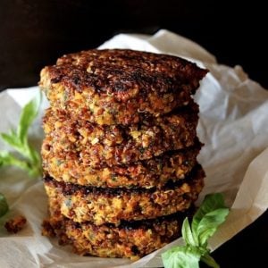 stack of quinoa burgers with fresh basil on parchment