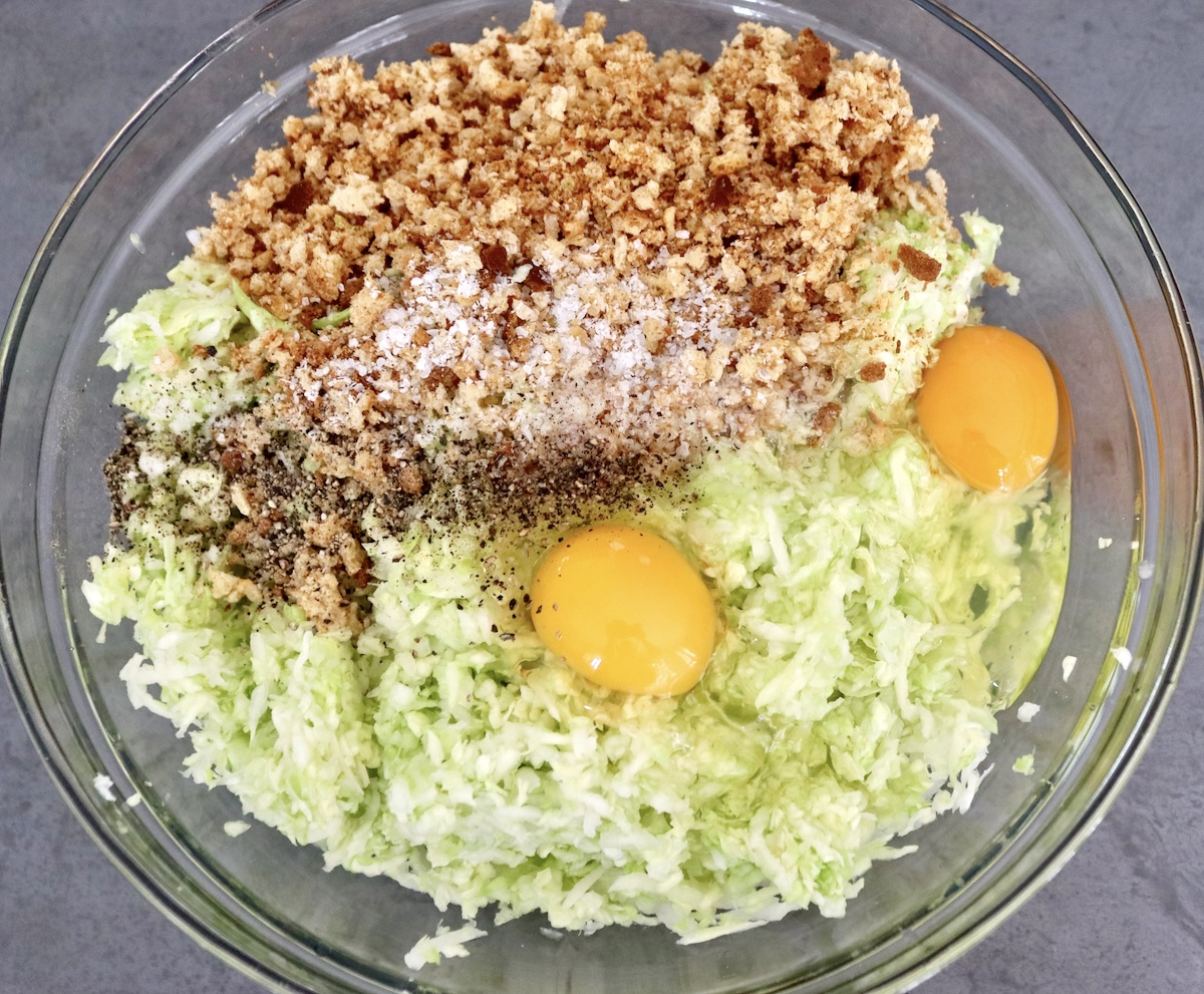 Cabbage-Potato-Pancakes Large glass bowl with grated cabbage, breadcrumbs and eggs.