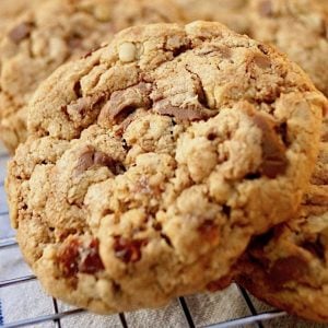 close up of an oatmeal raisin chocolate chip cookie on a cooling rack