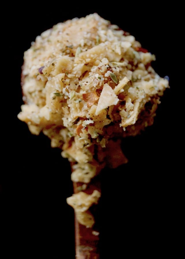Wooden spoonful of crushed tortilla chips mixed iwth spices